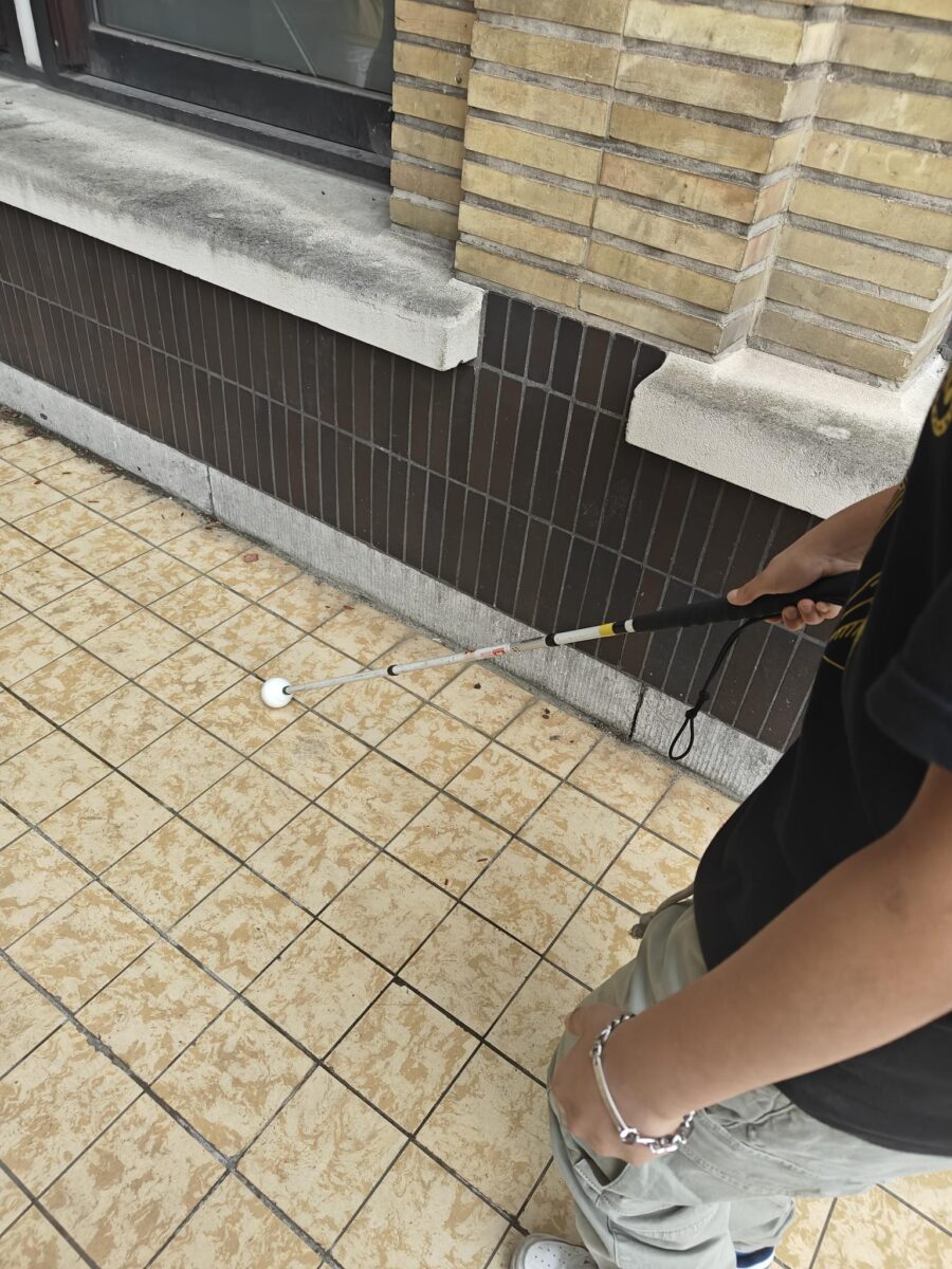 Leerling loopt met witte stok door de gang
