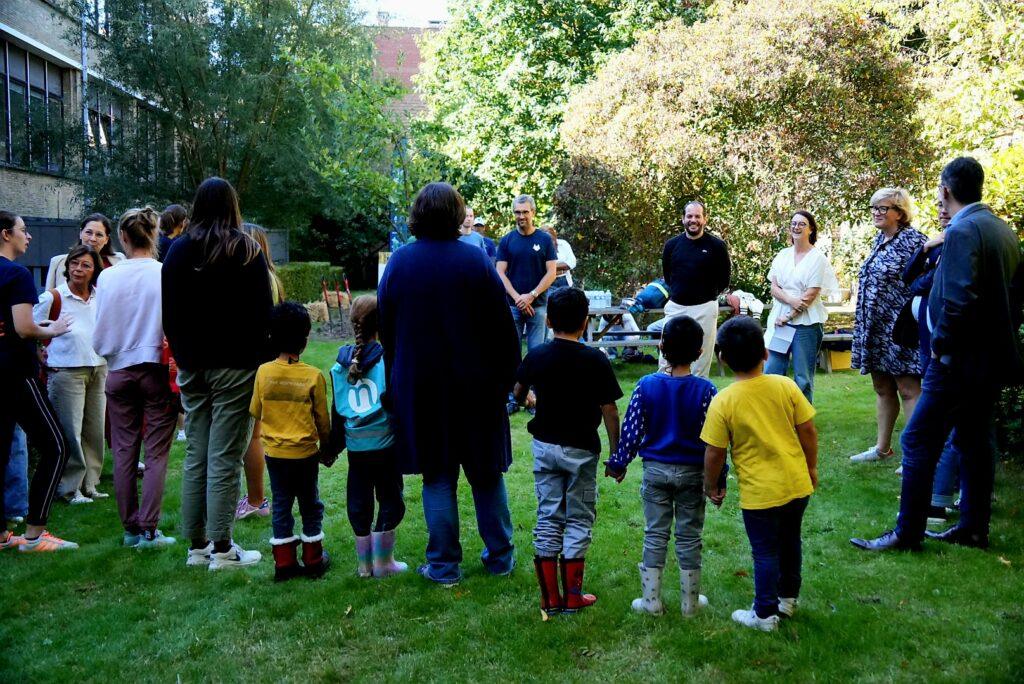 Leerlingen en begeleiders/leerkrachten luisteren naar openingsspeeches bij de start van het planten van het schoolbos.