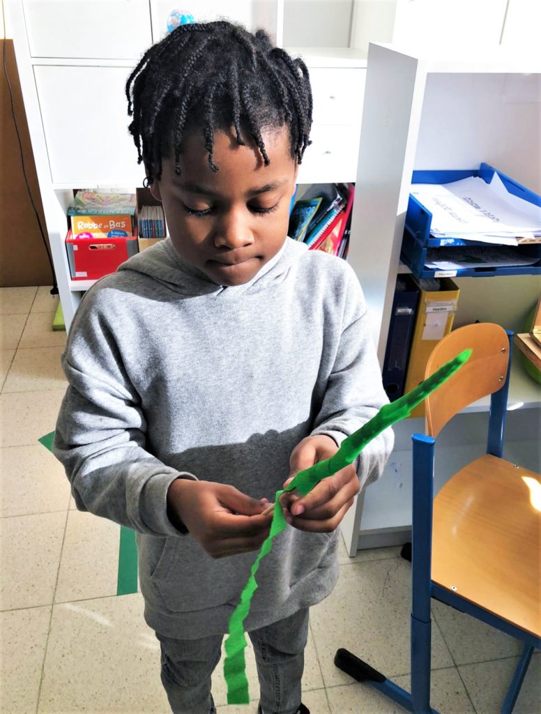 Kind knutselt in de klas van de lagere school