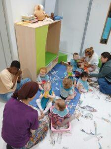 Leerlingen van de studierichting opvoeding en begeleiding spelen met enkele baby's.
