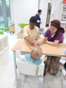 Twee leerlingen van de studierichting opvoeding en begeleiding geven een baby te eten.
