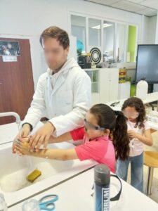 Leerling van de richting opvoeding en begeleiding helpt twee jongere kinderen.