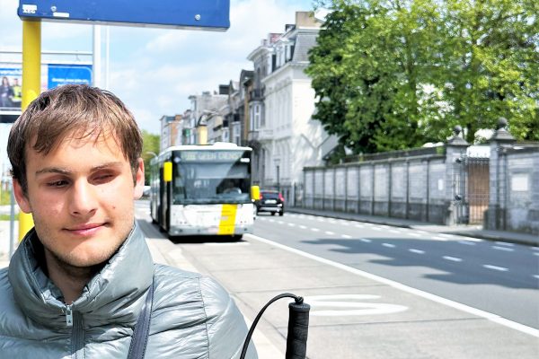 Slechtziendend jongen wacht op de bus